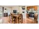 Bright dining area featuring hardwood floors, a wooden table, and an adjacent kitchen with stainless steel appliances at 4828 S Nucla Way, Aurora, CO 80015