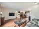 Open living space featuring hardwood floors, a TV, connecting the living room to the kitchen and dining area at 4828 S Nucla Way, Aurora, CO 80015