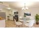 Inviting dining area showcases a modern chandelier, a glass table with seating, and updated kitchen appliances at 12180 Melody Dr # 203, Westminster, CO 80234