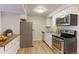 Well-maintained kitchen featuring stainless steel appliances, white cabinetry, modern countertops, and hardwood flooring at 12180 Melody Dr # 203, Westminster, CO 80234