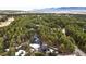 Stunning aerial view of a modern home nestled in a lush forest with mountain views at 19185 Shadowood Dr, Monument, CO 80132