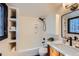 This modern bathroom features white tile, black fixtures, and built-in shelving for added storage at 19185 Shadowood Dr, Monument, CO 80132