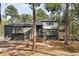 Modern home surrounded by trees, featuring a dark exterior, wood accents and inviting decks for outdoor living at 19185 Shadowood Dr, Monument, CO 80132