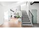 Bright foyer featuring wood floors, a skylight, and a staircase leading to the upper level of the home at 19185 Shadowood Dr, Monument, CO 80132