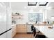 Bright kitchen featuring natural wood cabinets, skylights, an open window, and white countertops, showcasing a modern design at 19185 Shadowood Dr, Monument, CO 80132