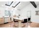 Modern kitchen with large island, skylights, wood cabinetry, white countertops, and stainless-steel appliances at 19185 Shadowood Dr, Monument, CO 80132