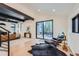 Open-concept living area featuring a sleek leather sofa, modern chair, and access to the outdoor deck through sliding glass doors at 19185 Shadowood Dr, Monument, CO 80132