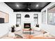 Cozy living room featuring a fireplace, white armchairs, and a leather sofa with natural light at 19185 Shadowood Dr, Monument, CO 80132