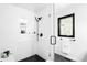Modern glass shower showcasing sleek black fixtures, white tiled walls, and a convenient built-in niche at 19185 Shadowood Dr, Monument, CO 80132