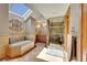 Luxurious bathroom featuring a soaking tub, walk-in shower with stone surround, and skylight at 8136 S Glencoe Ct, Centennial, CO 80122