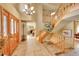 Elegant entryway with a chandelier, wood door, staircase and tile flooring at 8136 S Glencoe Ct, Centennial, CO 80122
