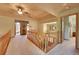 Upstairs hallway featuring wood railing and carpeted floors, overlooking the front entryway at 8136 S Glencoe Ct, Centennial, CO 80122