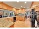 Bright kitchen with light wood cabinetry, granite countertops, and modern black appliances at 8136 S Glencoe Ct, Centennial, CO 80122