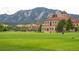 Scenic campus view with historic brick buildings, green lawn, and majestic mountain backdrop at 1111 Maxwell Ave # 228, Boulder, CO 80304