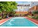 Inviting community pool surrounded by lush landscaping and multi-level townhomes with wooden decks at 1111 Maxwell Ave # 228, Boulder, CO 80304