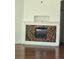 A decorative fireplace with a white mantel and light and dark brown mosaic tile surround at 11761 E Canal Dr, Aurora, CO 80011