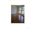 Bright, empty living room featuring hardwood floors and large windows at 11761 E Canal Dr, Aurora, CO 80011