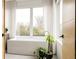 Serene bathroom with a modern soaking tub, large window, sheer curtains, and wood accents at 140 S Glencoe St, Denver, CO 80246