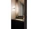 Modern powder room featuring a dark vanity with stone countertop and elegant lighting fixtures at 140 S Glencoe St, Denver, CO 80246
