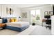 Modern bedroom featuring a blue platform bed, work space, and a bright window at 140 S Glencoe St, Denver, CO 80246