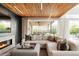 Comfortable living room featuring a modern fireplace, wood ceiling, and seamless indoor/outdoor flow to backyard at 140 S Glencoe St, Denver, CO 80246