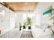 Bright living room with wooden ceiling, white couch, stylish rug, and large windows providing natural light at 140 S Glencoe St, Denver, CO 80246