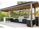 Well-equipped outdoor kitchen with stainless steel appliances and bar seating for entertaining by the pool at 140 S Glencoe St, Denver, CO 80246
