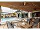 Relaxing covered patio with sleek ceiling, ceiling fans, outdoor seating, overlooking pool and outdoor kitchen at 140 S Glencoe St, Denver, CO 80246