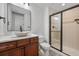 Bathroom featuring a custom vanity with a stone sink and a tiled walk-in shower at 7821 Inverness Blvd, Englewood, CO 80112