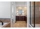 Beautiful bathroom with stone countertop, dark wood cabinets, and separate tub and shower at 7821 Inverness Blvd, Englewood, CO 80112