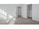 Bedroom featuring neutral carpet, white walls, and doorway to closet at 7821 Inverness Blvd, Englewood, CO 80112