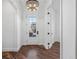 Bright foyer featuring hardwood floors, stylish lighting, and a decorative glass front door at 7821 Inverness Blvd, Englewood, CO 80112