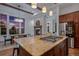 Well-lit kitchen featuring granite countertops, custom cabinets, stainless appliances, and an island with a gas range at 7821 Inverness Blvd, Englewood, CO 80112