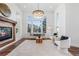 Bright living room features a stone fireplace, large windows, wood floors, and contemporary furnishings at 7821 Inverness Blvd, Englewood, CO 80112