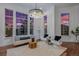 Bright living room featuring hardwood floors, a modern chandelier, and large windows with scenic views at 7821 Inverness Blvd, Englewood, CO 80112