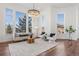 Bright living room with large windows, modern chandelier, hardwood floors, and neutral furnishings at 7821 Inverness Blvd, Englewood, CO 80112