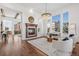 Bright living room with fireplace, large windows, wood floors, and contemporary furnishings, open to kitchen at 7821 Inverness Blvd, Englewood, CO 80112