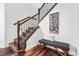 Elegant staircase with hardwood floors, iron railing, and a comfortable bench at 7821 Inverness Blvd, Englewood, CO 80112