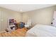 Bedroom features a bed and a white office chair on hard wood floors at 725 High St, Erie, CO 80516