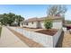Home exterior featuring light siding, white fence, gravel yard, and landscaping at 725 High St, Erie, CO 80516