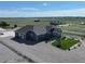 Stunning single-story home featuring gravel landscaping and a charming enclosed sunroom with beautiful green fields in the background at 31353 E 163Rd Ave, Hudson, CO 80642