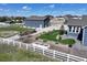 Well-manicured backyard featuring a decorative windmill, garden beds, and a white fence surrounding the property at 31353 E 163Rd Ave, Hudson, CO 80642