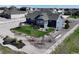 Beautifully landscaped backyard with lush green lawn, decorative windmill, garden beds, and elegant white fencing at 31353 E 163Rd Ave, Hudson, CO 80642