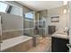 This bathroom features a glass-enclosed shower, soaking tub, neutral tile, and double sinks at 31353 E 163Rd Ave, Hudson, CO 80642