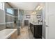 This bathroom features a glass-enclosed shower, soaking tub, neutral tile, double sinks and granite countertops at 31353 E 163Rd Ave, Hudson, CO 80642