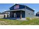 Charming home featuring a covered porch with brick pillars and adorned with an American flag, set in a grassy yard at 31353 E 163Rd Ave, Hudson, CO 80642