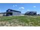 A home and detached garage, featuring a spacious lawn enclosed by a white fence, under a bright sky at 31353 E 163Rd Ave, Hudson, CO 80642