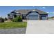 Beautiful exterior view of a craftsman-style home with a wide driveway and three-car garage at 31353 E 163Rd Ave, Hudson, CO 80642