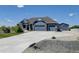 A large craftsman-style home with an extensive driveway and a three-car garage plus separate small garage at 31353 E 163Rd Ave, Hudson, CO 80642