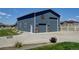 Spacious garage with a double door, side entrance, stylish siding, and ample parking space on a gravel driveway at 31353 E 163Rd Ave, Hudson, CO 80642